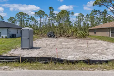 Wooded Lehigh Acres residential parcel partly opened around a future building footprint